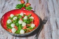 A plate of fresh salad with arugula, cherry tomatoes, mozzarella cheese on a white, shabby, wooden table. vertical view. Copy Royalty Free Stock Photo