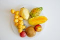 Plate with fresh tropical fruits on white background