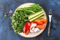 Plate with fresh vegetable sliced salad with cucumber, tomato, pepper and dill, parsley on blue background Royalty Free Stock Photo