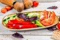 Plate with fresh vegetables pepper, cucumber, tomatoes, basil Royalty Free Stock Photo