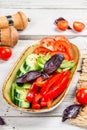 Plate with fresh vegetables pepper, cucumber, tomatoes, basil Royalty Free Stock Photo