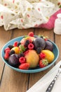 Plate with fresh whole berries and fruits peach, plum, strawberry and blackberry on wooden table Royalty Free Stock Photo