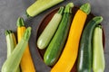 Plate with fresh zucchinis on grey table