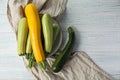 Plate with fresh zucchinis on white wooden table