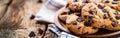 A plate with freshly baked American chocolate chip cookies sitting on a rustic wooden table Royalty Free Stock Photo