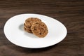 Plate of freshly baked chocolate chip cookies. Wooden background, selective focus Royalty Free Stock Photo