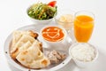 Plate of freshly prepared Cheese Nan with a glass of mango juice on a white background