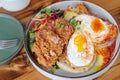 A plate of fried chicken, eggs, and toast is served on a wooden table Royalty Free Stock Photo