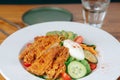 A plate of fried chicken salad with a glass of water Royalty Free Stock Photo