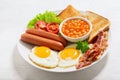 plate of fried eggs with bacon  beans  sausages  toasts and tomatoes Royalty Free Stock Photo
