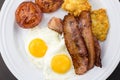 Plate with fried eggs, bacon, tomato and hash brown patties close up Royalty Free Stock Photo