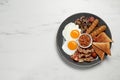 Plate of fried eggs, mushrooms, beans, tomatoes, bacon, sausages and toasts on marble table, top view. Traditional English Royalty Free Stock Photo