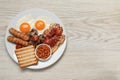 Plate of fried eggs, sausages, mushrooms, beans, bacon and toast on white wooden table, top view with space for text. Traditional Royalty Free Stock Photo