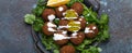Plate of fried falafel balls served with fresh green cilantro and lemon, top view on rustic concrete background