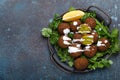 Plate of fried falafel balls served with fresh green cilantro and lemon top view on rustic concrete background