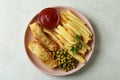 Plate with fried fish and chips, ketchup, parsley and pea on white textured background Royalty Free Stock Photo