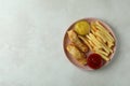 Plate with fried fish and chips, and sauces on white textured background