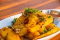 A plate of fried potato wedges with spicy herbs on top Royalty Free Stock Photo