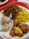 A plate of fried rice and fried noodle with orange chicken and crispy mayonnaise shrimp from chinese take out Royalty Free Stock Photo