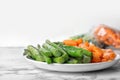 Plate with frozen vegetables on table Royalty Free Stock Photo