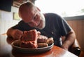 A plate full of barbecues and a man looking very excited to eat it Royalty Free Stock Photo