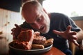 A plate full of barbecues and a man looking very excited to eat it Royalty Free Stock Photo