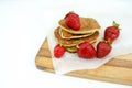 Plate full of fluffy golden pancakes with strawberries on the wooden board Royalty Free Stock Photo