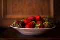 A plate full of fresh strawberries picked from the village garden. photographed in natural light with blurred wooden background Royalty Free Stock Photo