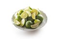 Plate full of fresh whole and wedged limes on a white background Royalty Free Stock Photo