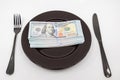 Plate full hundreds of dollar bills with fork and knife. Concept of prosperity and abundance. Full plate concept. Copy space Royalty Free Stock Photo