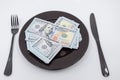 Plate full hundreds of dollar bills with fork and knife. Concept of prosperity and abundance. Full plate concept. Copy space Royalty Free Stock Photo