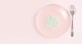 A plate full of microplastics on a pink background. Impact of micro plastic in food chain. The concept of plastic pollution.
