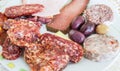 Plate full of slices of different types of meat and olives