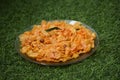 Plate full of spicy corn flakes plated on green grass Royalty Free Stock Photo