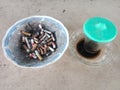 A plate of garbage from cigarettes and leftover coffee Royalty Free Stock Photo