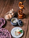 a plate of German cheese dish, with a basket of bread on a wooden table Royalty Free Stock Photo
