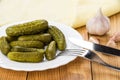 Plate with gherkins, fork, garlic and yellow napkin