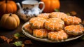 Plate with glazed ginger orange homemade gingerbread cookies on a holiday table decorated with autumn leaves and pumpkins