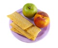 A plate with green apple, peach and three crisps