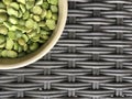 Plate with green peas on a dark wicker texture.