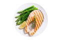 Plate of grilled salmon steak with asparagus isolated on white background Royalty Free Stock Photo