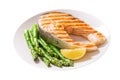 plate of grilled salmon steak with asparagus on white background Royalty Free Stock Photo