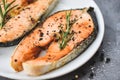 Plate of grilled salmon steak  with herbs and spices rosemary on black background - Close up cooked salmon fish fillet steak Royalty Free Stock Photo