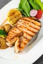 Plate of grilled salmon steak with vegetables on dark stone table Royalty Free Stock Photo