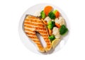 Plate of grilled salmon steak with vegetables isolated on white background Royalty Free Stock Photo