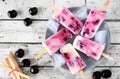Plate of healthy cherry yogurt ice pops, table scene over rustic white wood Royalty Free Stock Photo