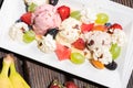 Plate of healthy fresh fruit salad with ice cream on the wooden background. Top view Royalty Free Stock Photo