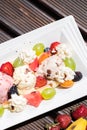 Plate of healthy fresh fruit salad with ice cream on the wooden background. Top view Royalty Free Stock Photo