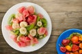 Plate of healthy fresh fruit salad on wooden background Royalty Free Stock Photo