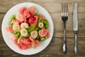 Plate of healthy fresh fruit salad on wooden background Royalty Free Stock Photo